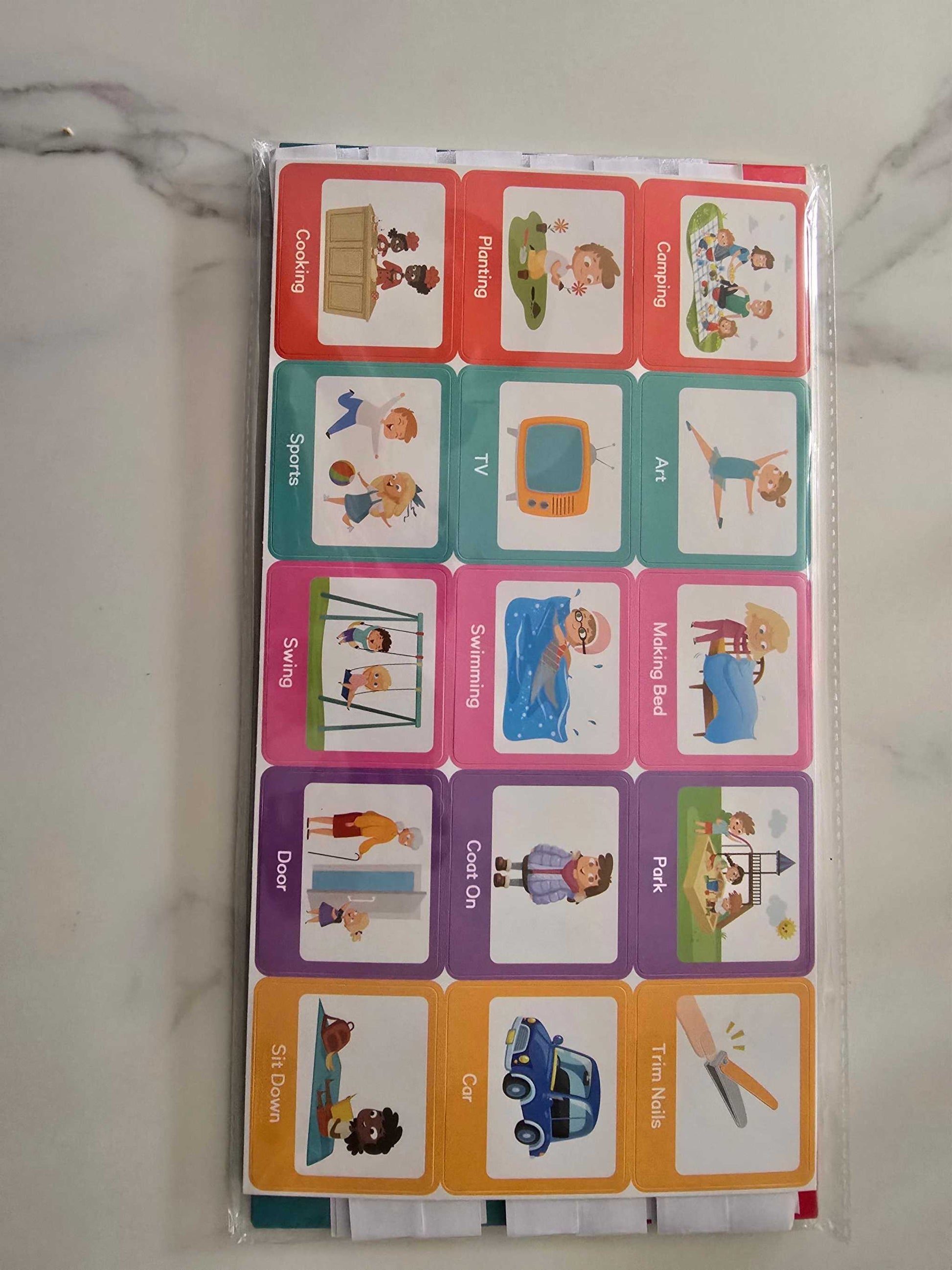 Travel themed activity cards with illustrations for children including cooking, painting, camping, sports, TV, art, swings, swimming, making bed, door, coat on, park, sit down, car, and tim noks.